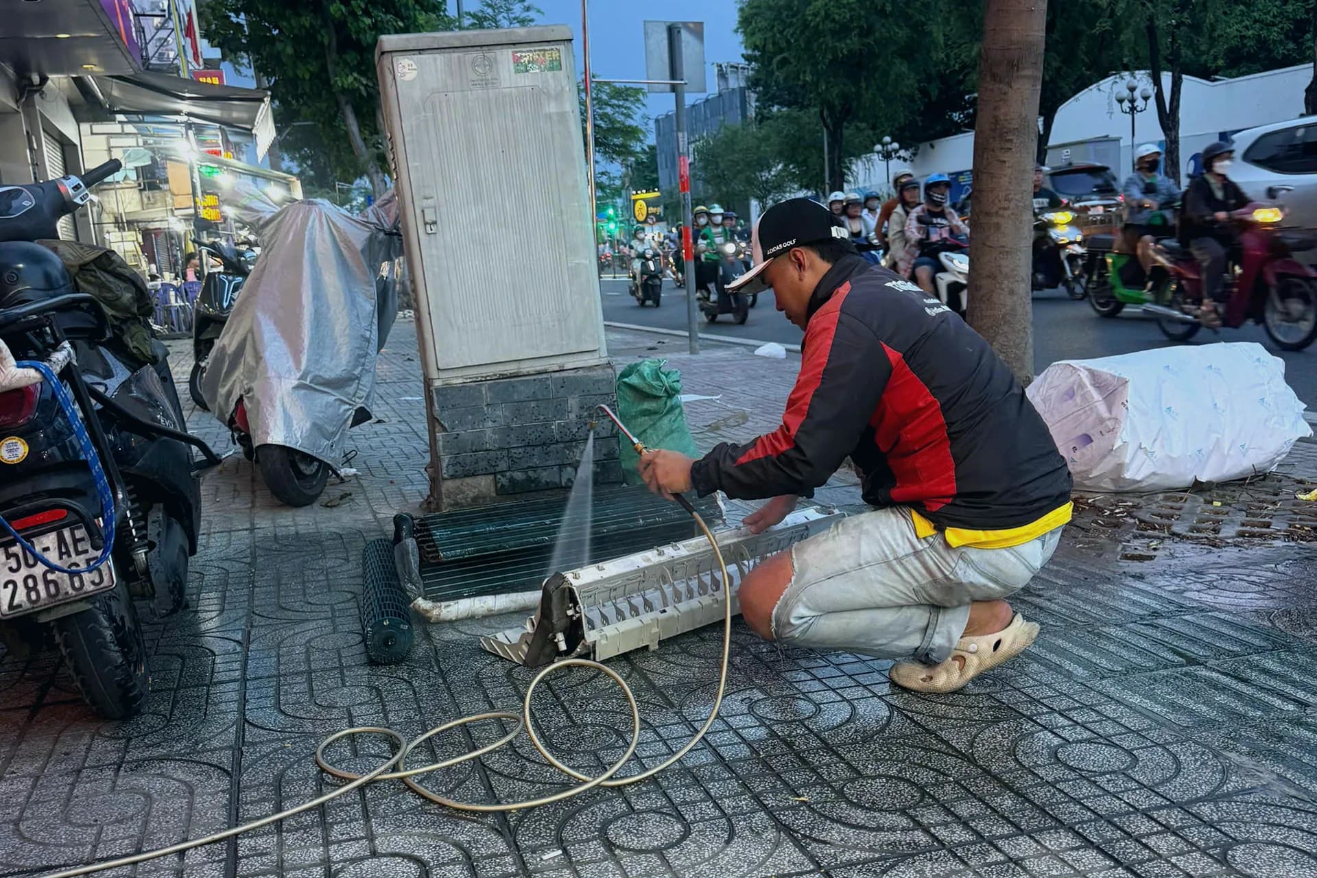 Kỹ thuật viên Điện Lạnh Thái Tuấn đang vệ sinh dàn lạnh máy lạnh bằng máy xịt áp lực